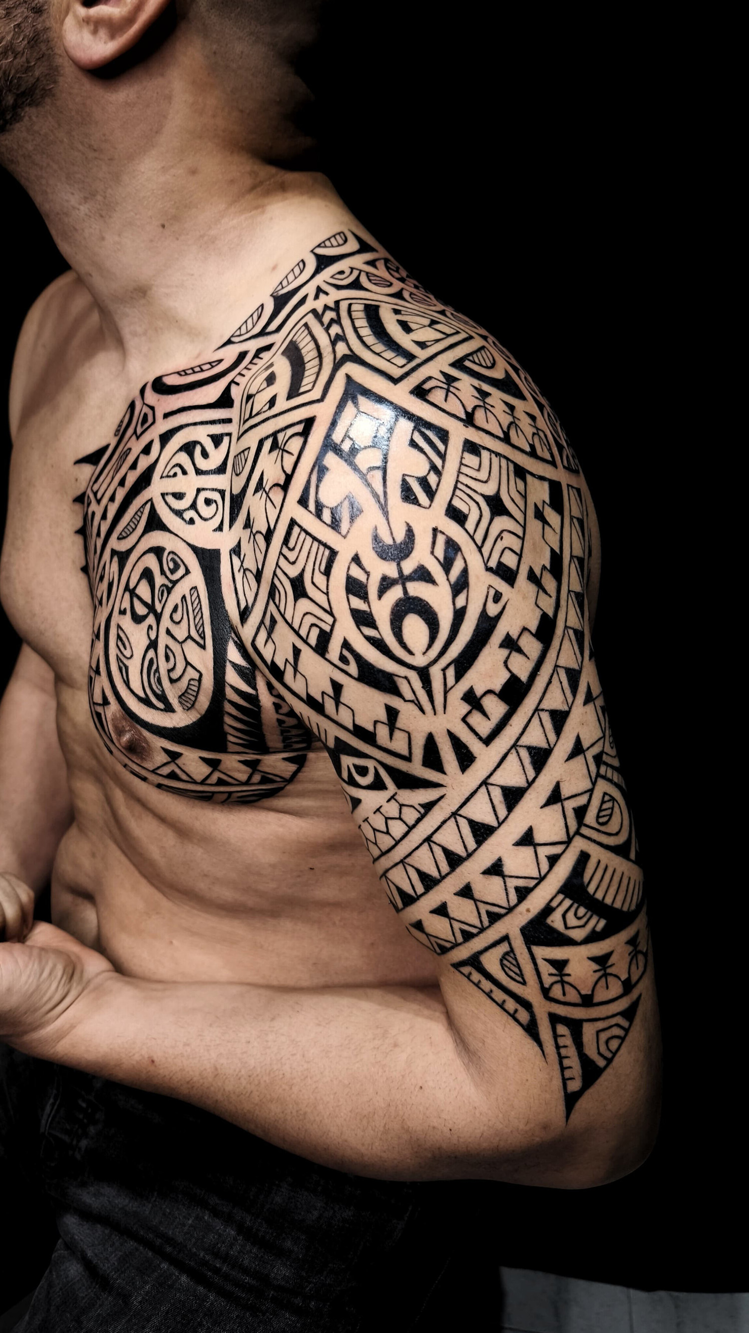 Tatuaje polinesio en pectoral y brazo