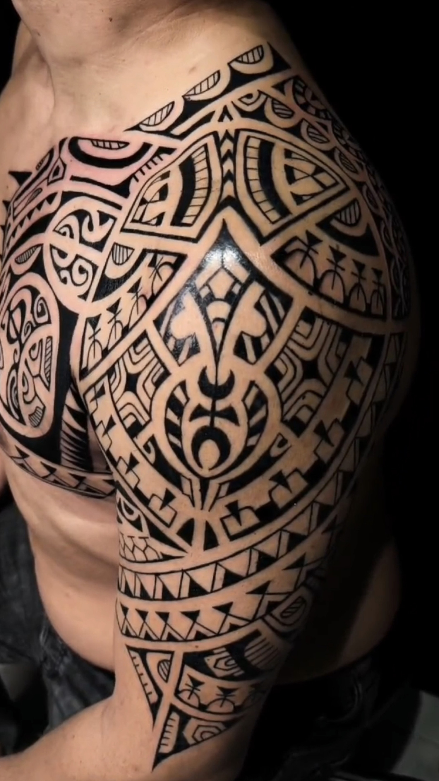 Tatuaje con símbolos polinesios en el brazo